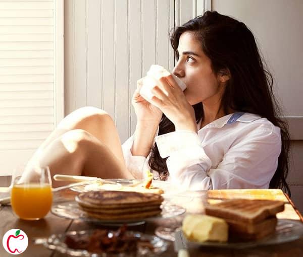 زنی جوان در حال خوردن صبحانه - تنظیم هورمون های بدن - سیوطب